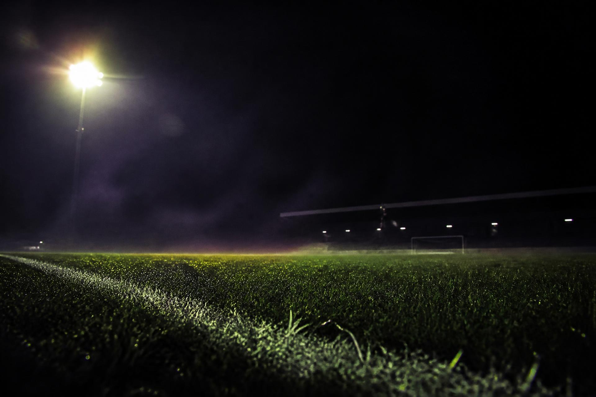 Floodlit football pitch at night